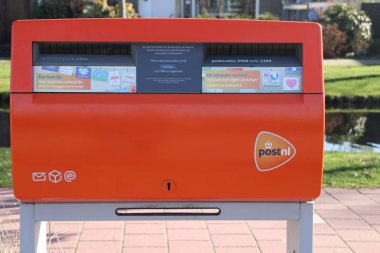 Mailbox on the streets of the Netherlands owned by PostNL with dynamic sign of moment when post is collected clipart