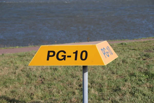 在荷兰鹿特丹港 地下管道上方的黄色三角形警示牌 上面有标签号 — 图库照片