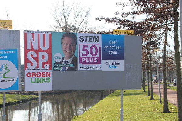 Плакаты избирательной кампании на общественных рекламных щитах, размещенные самими партиями в nIeuwerkerk aan den Ijssel в Нидерландах
