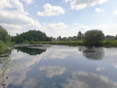 Park Hitland Capelle aan den Ijssel su yüzeyinde yansıtan beyaz bulutlar ve mavi gökyüzü