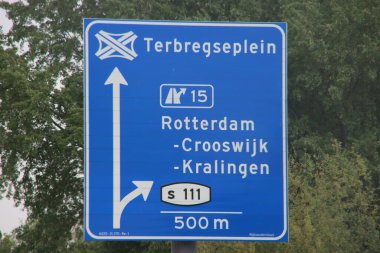 Rotterdam Crooswijk ve Kalingen istikametinde mavi ve beyaz yönlü yön tabelası A20 otoyolunda Terbregseplein S111 'e doğru ilerliyor. 