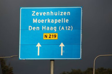 N219 yolundaki Zevenhuizen, Moerkapelle ve Den Haag istikametinde mavi ve beyaz yönlü işaret.