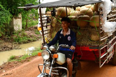 Kampong Chhnang; Kingdom of Cambodia - august 21 2018 : pottery in a motorbike in the picturesque village clipart