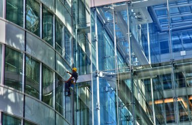 Paris La Defense; France - may 25 2017 : a man is cleaning windows in La Defense district, the biggest business distric in Europe clipart