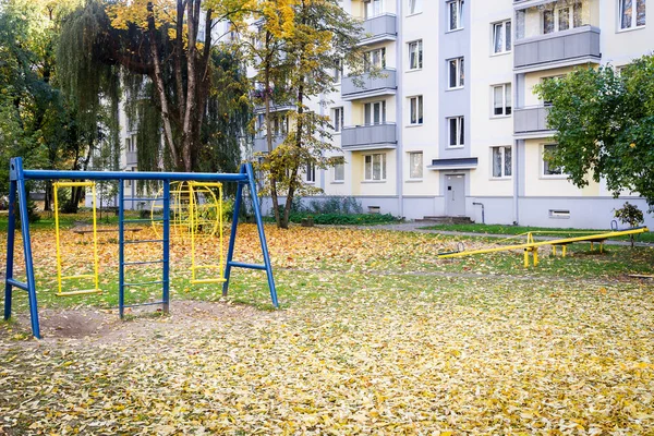 秋天由现代化的公寓楼旁的老儿童游乐场 — 图库照片