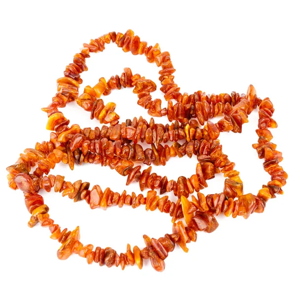 在白色背景上查出的一串串秃头琥珀色珠子 明亮的橙色琥珀项链的原始珠子在一堆 — 图库照片