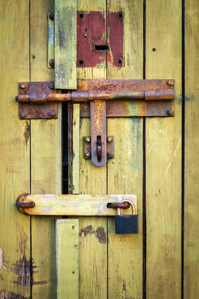 Stare drzwi żółte drewniane deski z kłódką — Zdjęcie stockowe