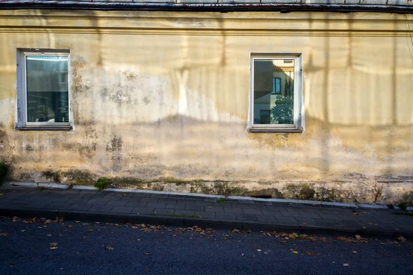 Oude gele muur met ramen — Stockfoto