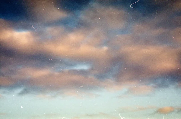 Grunge image of evening sky with clouds on grainy film texture — Stock Photo, Image