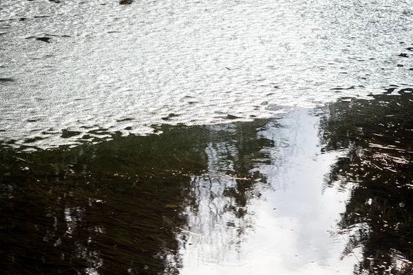 Oberfläche des Teiches mit schmelzendem Eis bedeckt — Stockfoto