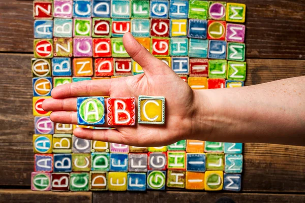 Hand som håller abc bokstäver — Stockfoto