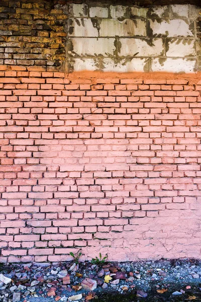 Stará žlutá cihlová zeď namalovaná růžovou barvou — Stock fotografie