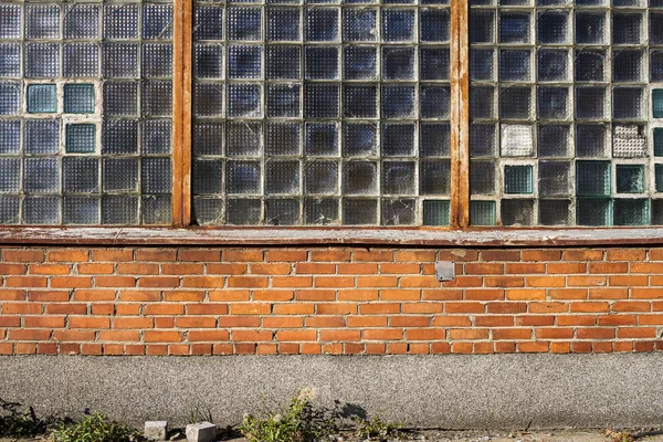Rød murvegg med vinduer i glassblokker – stockfoto