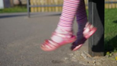 Kız legsclose depoyu sallanan yavaş hareket video kızlar/çocuk / çocuk'ın / bebek'ın sallanan bacaklar/ayaklar pembe çorap ve plastik kiraz, yandan filme ile pembe sandalet