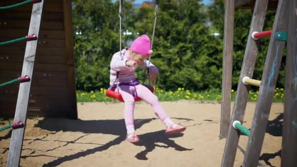 Mädchen Das Auf Einer Schaukel Reitet Und Auf Einem Kinderspielplatz — Stockvideo