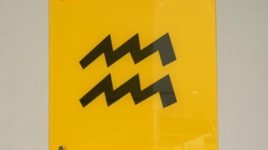 Aquarius astrolojik zodyak işaretleri Kova burcuyla yakın çekim sarı plaka ve burcun astrolojik işareti.