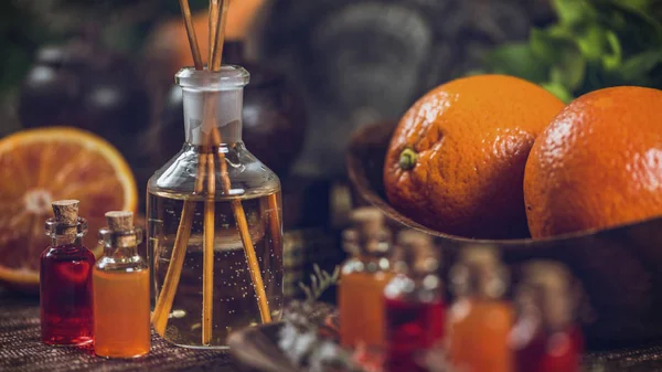 Прозорі Пляшки Наповнені Червоними Апельсиновими Ефірними Оліями Ароматними Паличками Столі — стокове фото