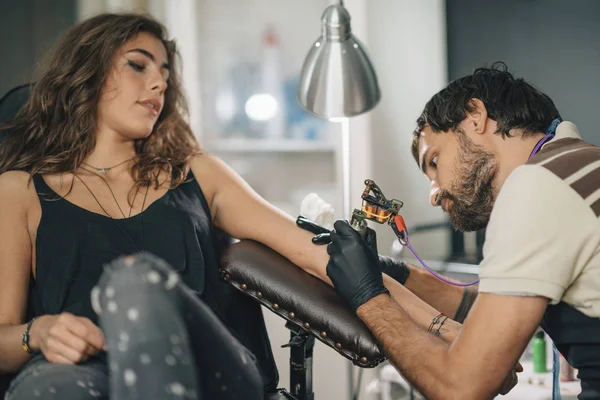 纹身主义者专注于女性客户的纹身工作 — 图库照片