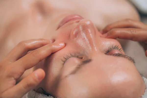 Kozmetik Uzmanı Genç Bir Kadının Yüzüne Masaj Yapıyor — Stok fotoğraf