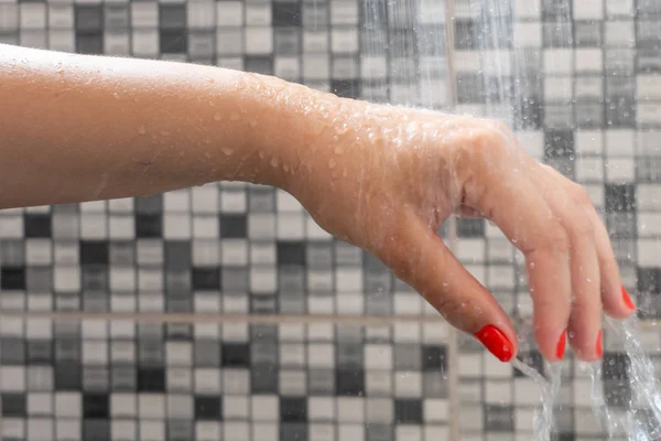 柔和的选择焦点的手和水滴的淋浴与图案背景 — 图库照片