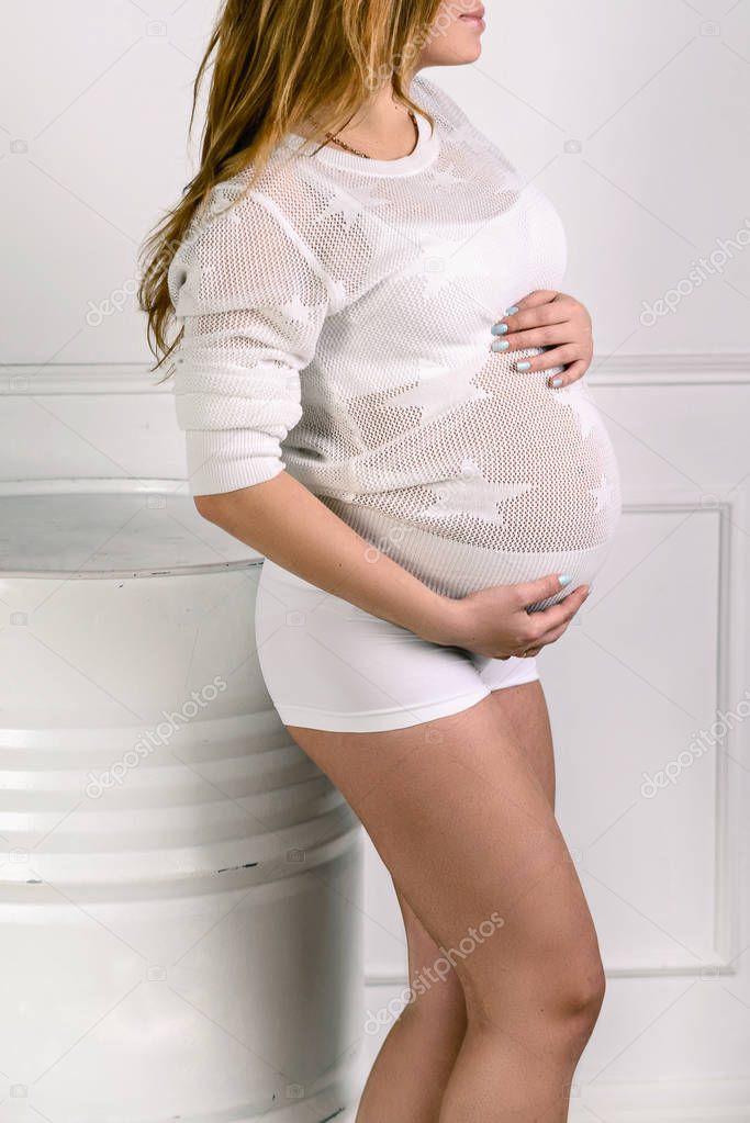 Pregnant woman holding her belly white background