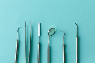 Diş hekimliğindeki profesyonel dişçi aletleri: dişçi aynası, forseps kıvrımlı, kaşif kıvrımlı, diş kâşifi açılı ve kaşif çip ile kıvrımlı, doğru. Diş hijyeni ve sağlık kavramsal imajı