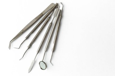 Diş hekimliğindeki profesyonel dişçi aletleri: dişçi aynası, forseps kıvrımlı, kaşif kıvrımlı, diş kâşifi açılı ve kaşif çip ile kıvrımlı, doğru. Diş hijyeni ve sağlık kavramsal imajı
