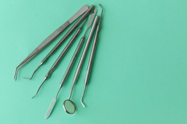 Diş hekimliğindeki profesyonel dişçi aletleri: dişçi aynası, forseps kıvrımlı, kaşif kıvrımlı, diş kâşifi açılı ve kaşif çip ile kıvrımlı, doğru. Diş hijyeni ve sağlık kavramsal imajı