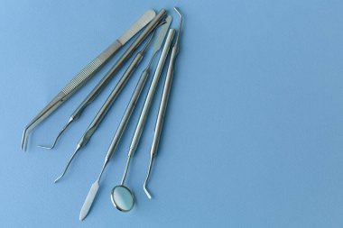 Diş hekimliğindeki profesyonel dişçi aletleri: dişçi aynası, forseps kıvrımlı, kaşif kıvrımlı, diş kâşifi açılı ve kaşif çip ile kıvrımlı, doğru. Diş hijyeni ve sağlık kavramsal imajı