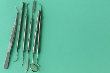 Diş hekimliğindeki profesyonel dişçi aletleri: dişçi aynası, forseps kıvrımlı, kaşif kıvrımlı, diş kâşifi açılı ve kaşif çip ile kıvrımlı, doğru. Diş hijyeni ve sağlık kavramsal imajı