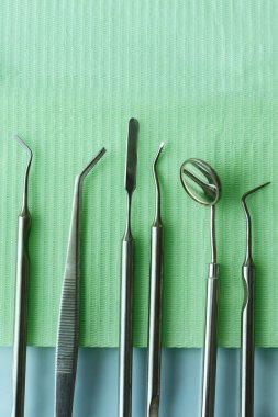 Diş hekimliğindeki profesyonel dişçi aletleri: dişçi aynası, forseps kıvrımlı, kaşif kıvrımlı, diş kâşifi açılı ve kaşif çip ile kıvrımlı, doğru. Diş hijyeni ve sağlık kavramsal imajı