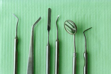 Diş hekimliğindeki profesyonel dişçi aletleri: dişçi aynası, forseps kıvrımlı, kaşif kıvrımlı, diş kâşifi açılı ve kaşif çip ile kıvrımlı, doğru. Diş hijyeni ve sağlık kavramsal imajı