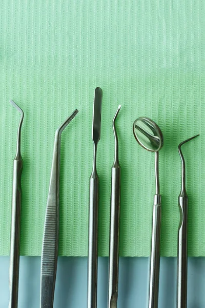 Professional Dentist tools in dental office: dentist mirror, forceps curved, explorer curved, dental explorer angular and explorer curved with chip, right. Dental Hygiene and Health conceptual image