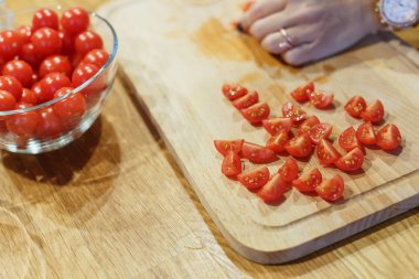 kesme kiraz domates ahşap kesme tahtası seçici odak üstünde el