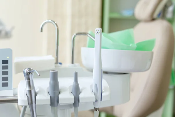 Diversi strumenti e strumenti dentali in uno studio dentistico da vicino sfondo e la sedia — Foto Stock