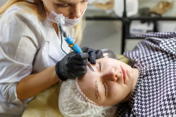 Микролезные брови работают в салоне красоты. Женщине тонировали брови. Полупостоянный макияж для бровей. Сосредоточьтесь на моделях лица и бровей — стоковое фото