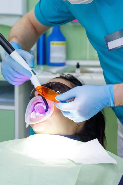 Mosolygó csinos nő, amelynek a fogait, vizsgálta fogorvos klinikán. Fogszuvasodás kezelése fogalmának — Stock Fotó
