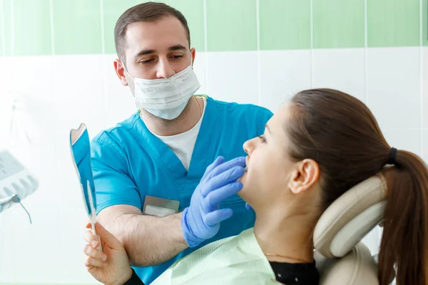 Mature male dentist working with woman patient visiting with a mirror dentist having dental checkup at the clinic dentistry occupation treatment medical industry healthcare people insurance — Stock Photo, Image