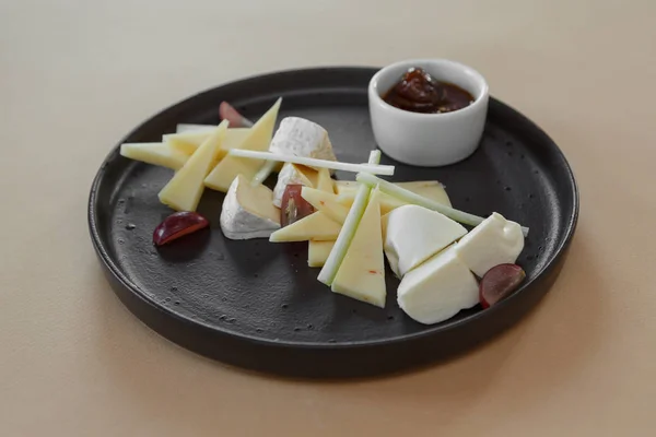 Сырная тарелка с разнообразными закусками на столе — стоковое фото