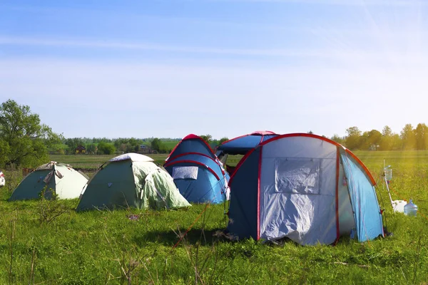 Tourist tents in the clearing. A place for camping on a meadow in nature in the summer. Adventure travels an active lifestyle outdoors.