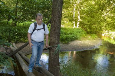 Bir gün yolculuk. Adam nehre köprüde geçiyor.