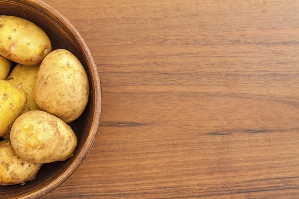 Bir kil kase çiğ patates yakın çekim.