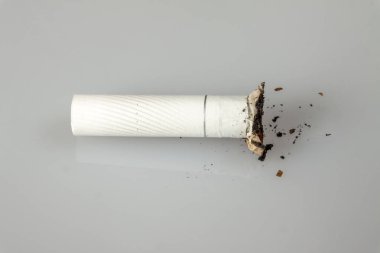 Sağlıklı yaşam konsepti. Küçük bir saplama ışık bir yüzeye, üste biraz kül yatıyor
