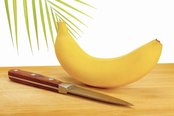 Uma Banana Fresca Com Uma Faca Está Deitada Uma Tábua — Fotografia de Stock