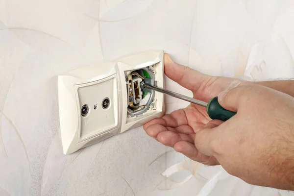 Repair of electrical outlets. Wire drawing with a screwdriver.