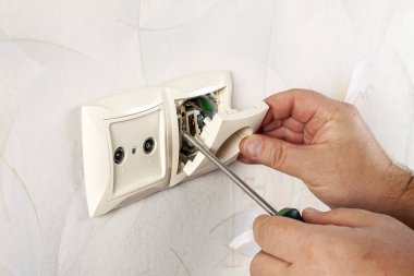Elektrik prizi tamiri. Tel bir tornavida ile çekme.