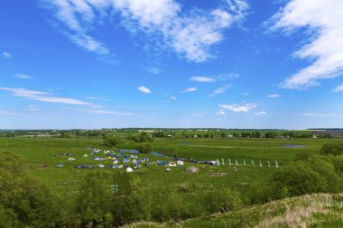 Turist kampı nehrin mavi gökyüzüne karşı kıyısında. Yüksek fotoğraf