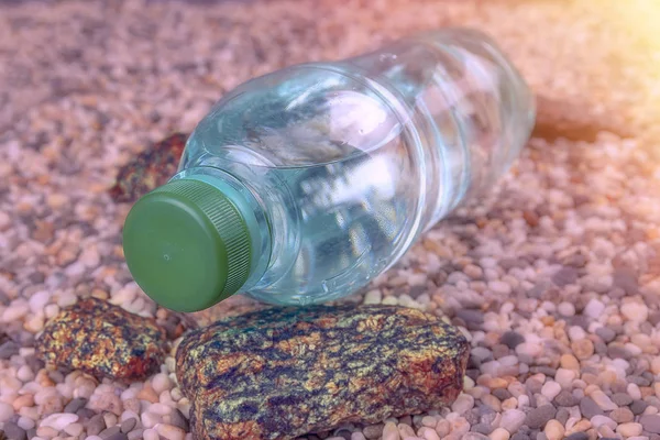 Vattenflaska på en sandstrand under sommarsolen — Stockfoto