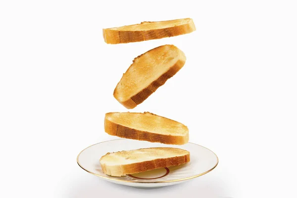 Toasts are falling on a saucer close-up on white background — Stock Photo, Image
