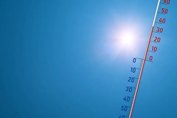 Le thermomètre sur fond bleu et au soleil éclatant montre 35 degrés de chaleur — Photo